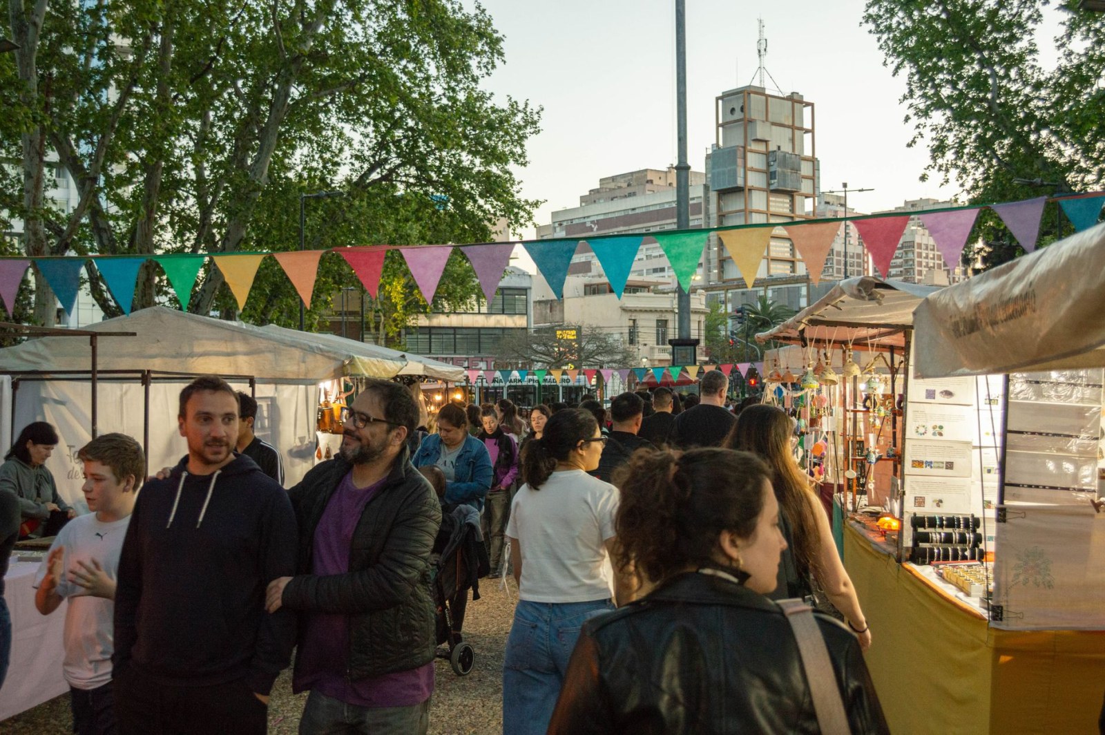 Animated scene of an open-air market in Buenos Aires with colorful stalls and people walking.
